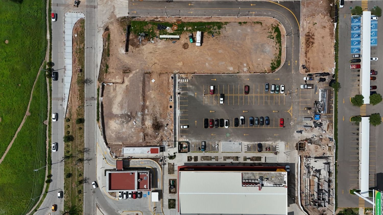 Aerial view of a parking lot beside a commercial construction site