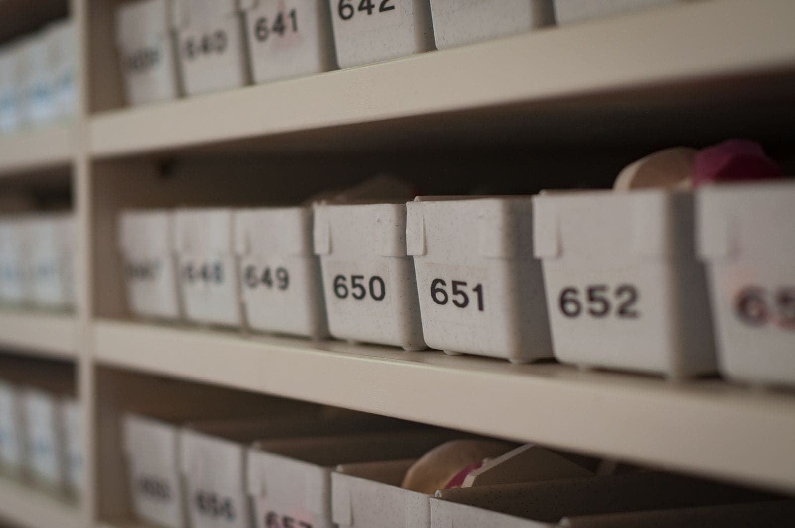 Rows of numbered white storage containers on shelves in an organized archive